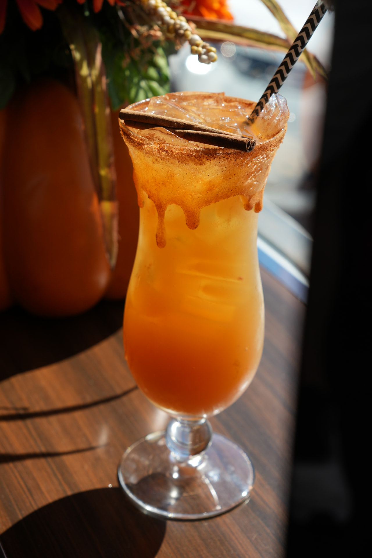 Spiced cider cocktail with a cinnamon stick and caramel rim